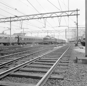 881605 Afbeelding van een electrische locomtief uit de serie 1200 van de N.S. met rijtuigen plan E bij het N.S.-station ...